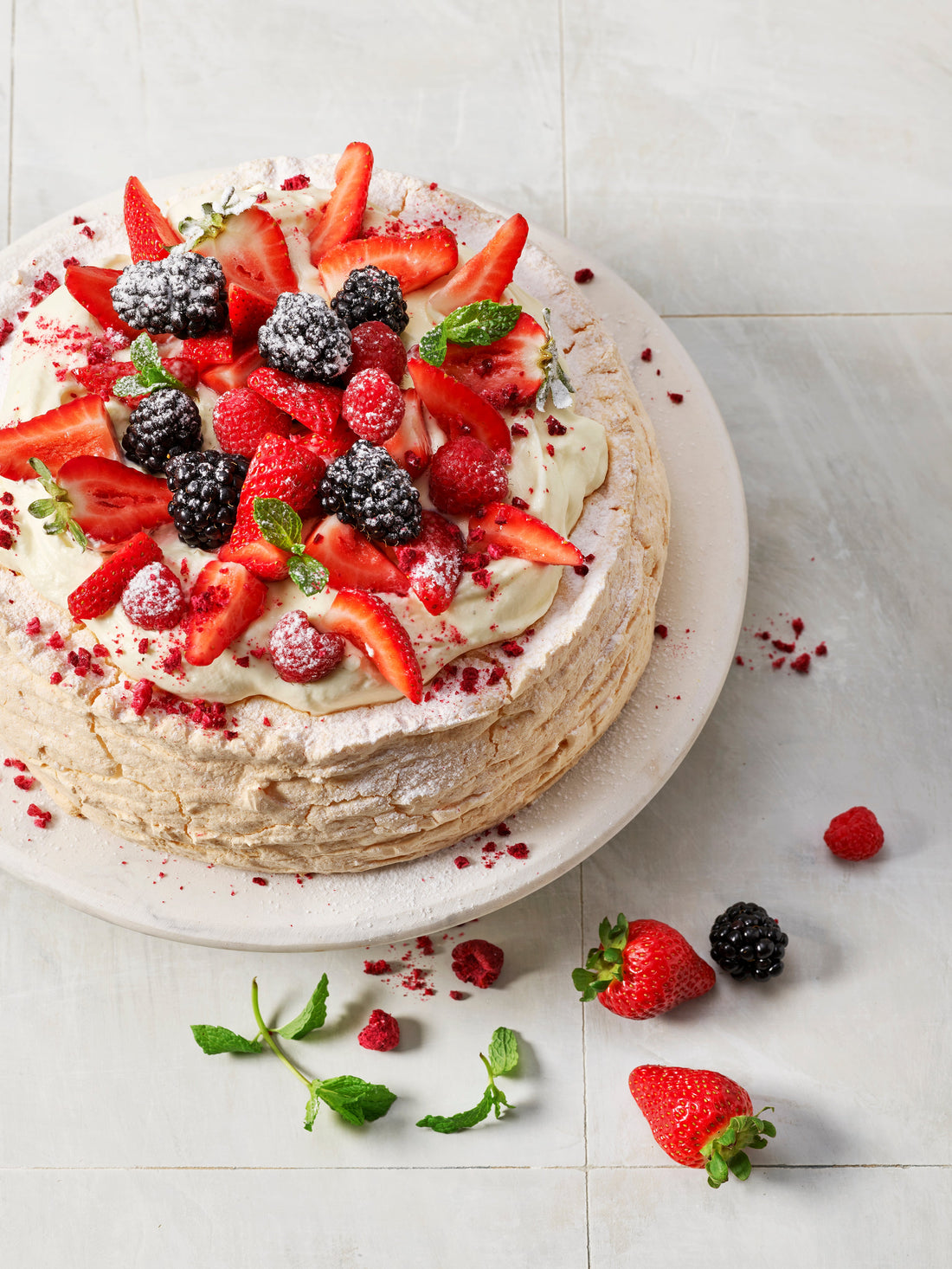 Cowell's pavlova topped with whipped cream and fresh summer berries