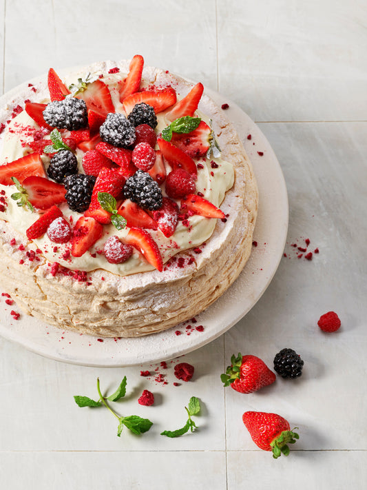 Cowell's pavlova topped with whipped cream and fresh summer berries